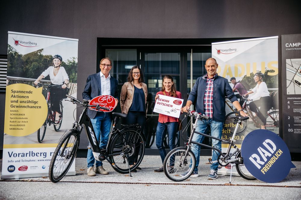 Die drei Radel-Lotto-Gewinnerinnen mit Landesrat Rauch und zwei Fahrrädern sowie dem Gewinn Gutschein.